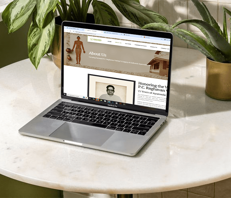 a image of showing a website page of raghavaa ayurveda pharmacy in a laptop on the table